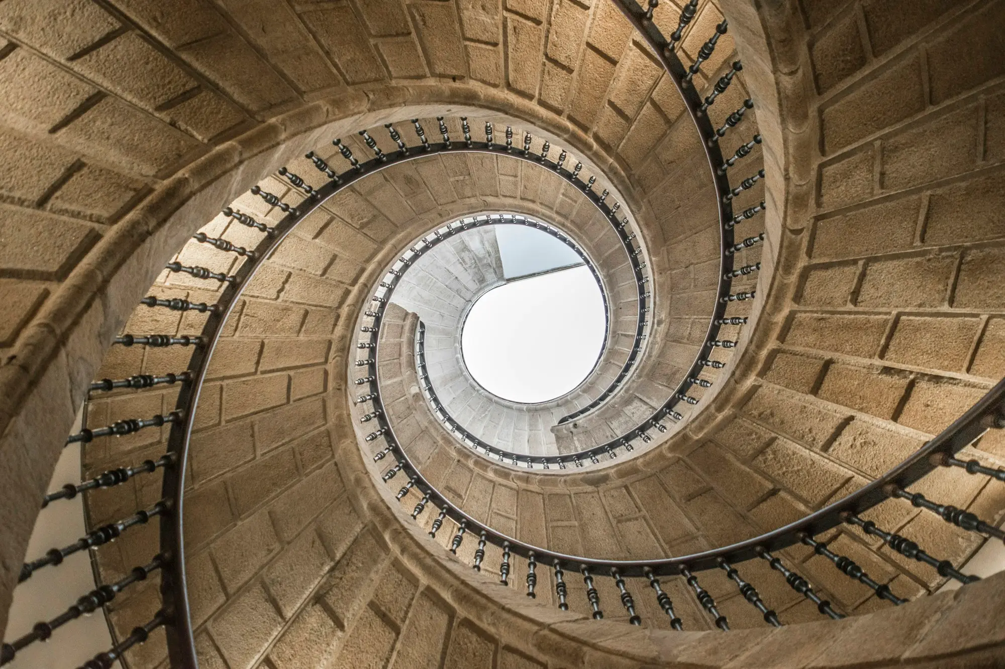 Escalier en colimaçon aux tons dorés vu d’en haut